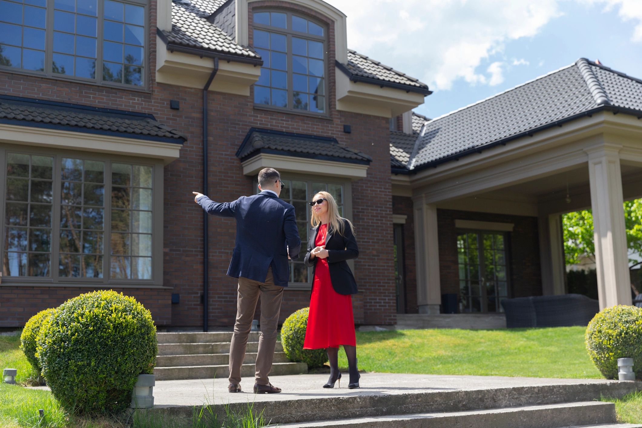real estate agent with client home exterior